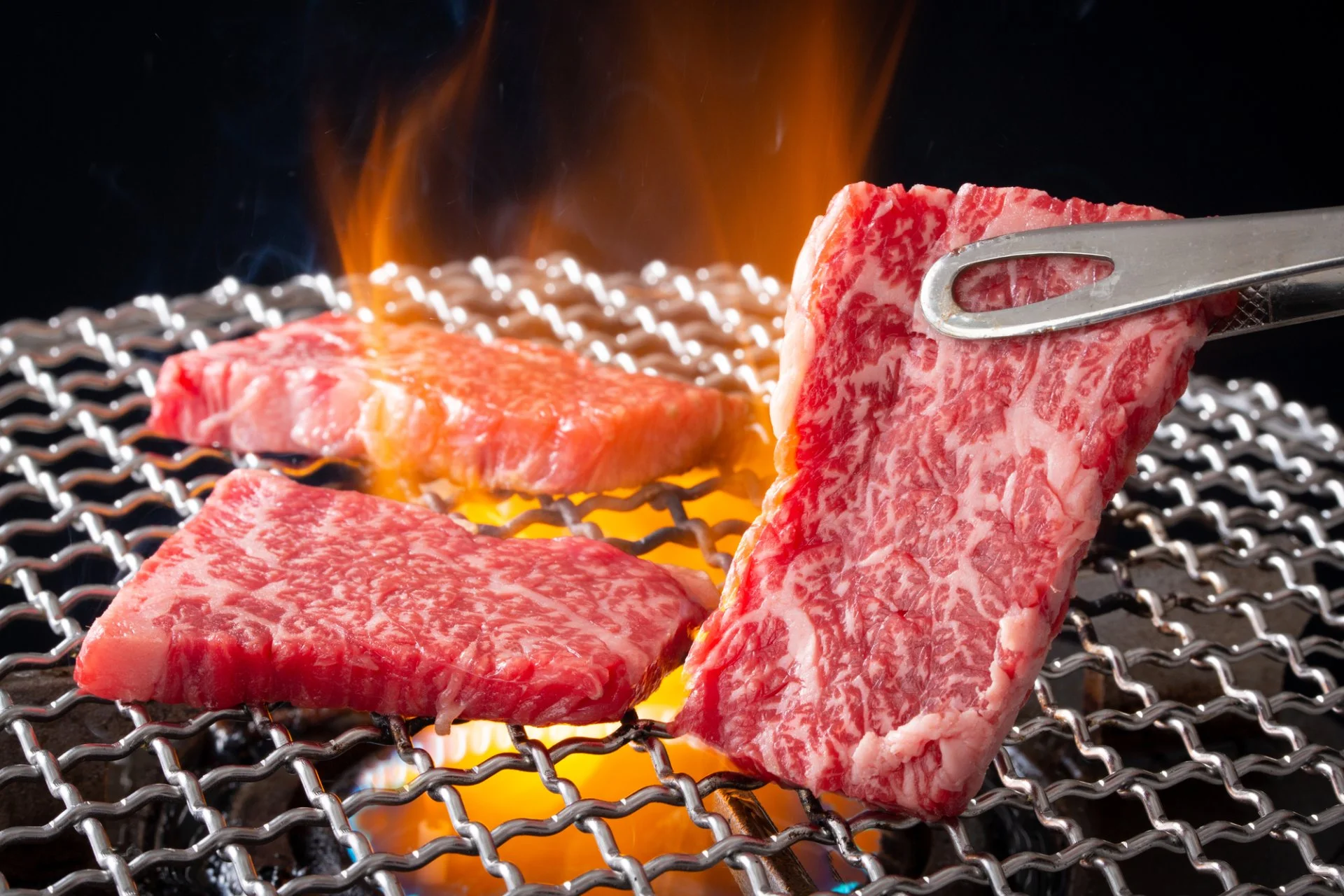 調理場で焼肉用の和牛を一枚ずつ丁寧に仕込む手元